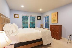 a bedroom with a bed and a dresser and windows at Glacier Pines in Glacier +38 photos
