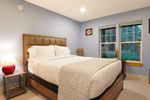 a bedroom with a large bed and two windows at Glacier Pines in Glacier
