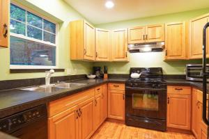 a kitchen with wooden cabinets and a sink and a stove at Glacier Pines in Glacier