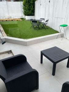 a patio with a table and chairs and grass at Quiet home in Denderleeuw