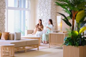 two women are sitting in a living room at Ooedo Onsen Monogatari Premium Atami in Atami