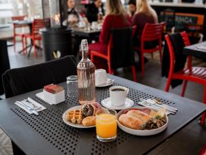 a table topped with plates of food and orange juice at Hotel Sommelier Agustinas in Santiago