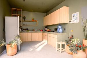 a kitchen with wooden cabinets and a refrigerator at Hospedarte Central Hotel in Guadalajara