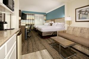 a hotel room with a bed and a couch at Holiday Inn Express Hotel & Suites - Paso Robles by IHG in Paso Robles