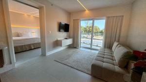 ein Wohnzimmer mit Sofa, Bett und Fernseher in der Unterkunft CDesign Hotel in Rio de Janeiro