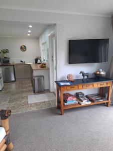 a living room with a flat screen tv on a wall at Among The Tuii in Katikati
