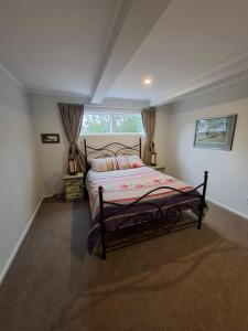 a bedroom with a bed and a window at Among The Tuii in Katikati