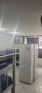 a kitchen with a white refrigerator and a bed at Hostel Princess Copacabana in Rio de Janeiro