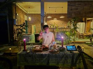 a man standing in front of a table with food at pesisircottage & stay in Selong Belanak +52 photos