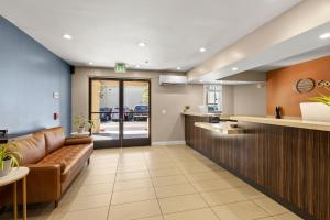 a lobby with a leather couch and a bar at Good Nite Inn Fremont in Fremont