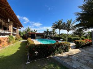 a house with a swimming pool in a yard at Pousada Sol Nascente in Beberibe