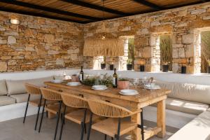 a wooden table with chairs and wine bottles on it at Villa Vanta in Drios