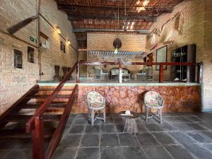 a room with two chairs and a bar in a building at Pousada Sol Nascente in Beberibe