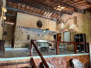 a large room with a brick wall and a fireplace at Pousada Sol Nascente in Beberibe