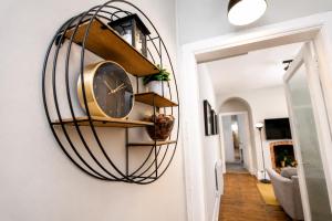 a clock hanging on a wall in a hallway at City Centre 1 Bed Apartment - Modern & Bright in Chester