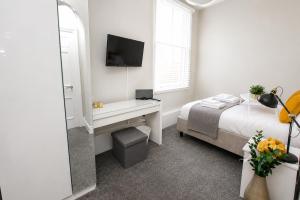 a white bedroom with a bed and a mirror at City Centre 1 Bed Apartment - Modern & Bright in Chester