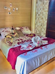 a bed with two stuffed animals sitting on it at Chalé Suíco Nupcial II - Chalés Belo Monte - Pacoti in Pacoti