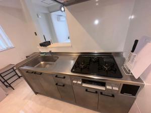 a kitchen with a stove and a sink at LIFEMENTGLANZ HOTEL Enomachi in Hiroshima +18 photos