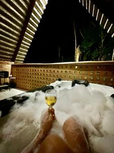 a glass of wine sitting in a bath tub at Chalé Suíco Nupcial II - Chalés Belo Monte - Pacoti in Pacoti