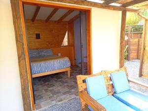 a bedroom with a bed and a mirror on a patio at Cabañas "Terrazas de Orión" con Vista Panorámica en Pisco Elqui in Pisco Elqui