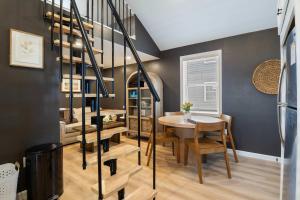 a dining room with a spiral staircase and a table at Coral Cottage - Tiny Home at Hampton Beach in Hampton