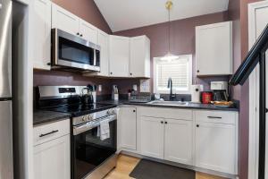 a kitchen with white cabinets and a microwave at Coastal Breeze Cottage - Tiny Home at Hampton Beach in Hampton