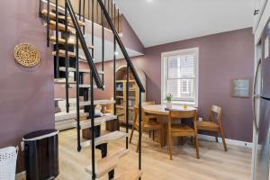 a dining room with a table and a spiral staircase at Coastal Breeze Cottage - Tiny Home at Hampton Beach in Hampton