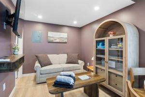 a living room with a couch and a table at Coastal Breeze Cottage - Tiny Home at Hampton Beach in Hampton