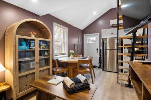 a kitchen and dining room with a table and a spiral staircase at Coastal Breeze Cottage - Tiny Home at Hampton Beach in Hampton +15 photos