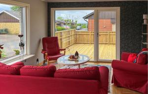 a living room with a red couch and two chairs at Lovely Home In Simrishamn With Wifi in Simrishamn