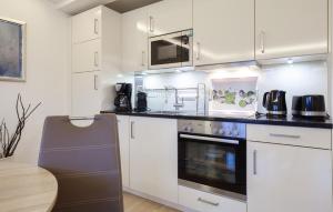 a kitchen with white cabinets and a stove top oven at Princess in Binz