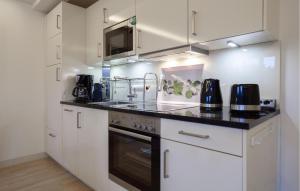 a kitchen with white cabinets and a black counter top at Princess in Binz