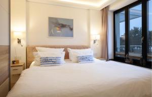 a bedroom with a large white bed with blue pillows at Princess in Binz