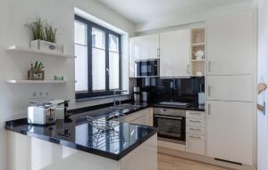 a kitchen with white appliances and a black counter top at Diamond in Binz