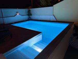 a swimming pool with blue lights in a backyard at Moradia com escada, Jardim e piscina, 3Kms Praia in Almada