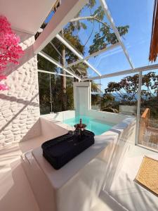 a white room with a table and a pool at Sítio Emanoel Bangalôs in Domingos Martins +64 photos