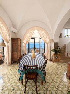 a dining room with a blue and white table and chairs at Luxury Maison Cherie - Positano Charme & Sea View in Positano