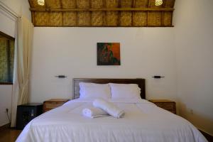 a white bed with two towels on top of it at Jati Rinjani Tetebatu in Tetebatu