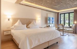 a bedroom with a large white bed and a desk at Baltic in Binz