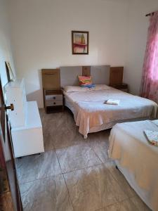 a room with two beds and a dresser in it at Recanto dos Braga in Saquarema