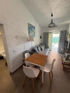 a living room with a wooden table and white chairs at parking terraza jumbo by stay in gran canaria in Playa del Ingles