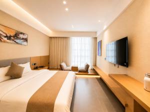 a hotel room with a large bed and a flat screen tv at Clover Hotel & Spa in Phnom Penh +23 photos