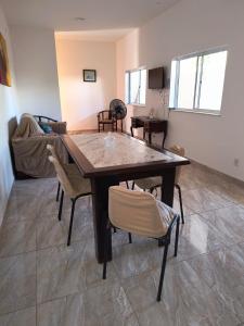 a dining room with a table and some chairs at Recanto dos Braga in Saquarema +9 photos