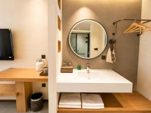 a bathroom with a sink and a mirror at Clover Hotel & Spa in Phnom Penh