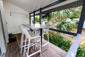 a patio with a table and chairs on a deck at Great Keppel Island Hideaway in Great Keppel