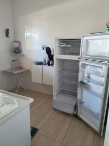a kitchen with an empty refrigerator with its door open at Recanto dos Braga in Saquarema