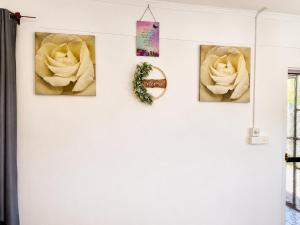 a white wall with three roses on it at The Beloved Corner in Nausori
