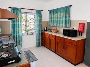 a kitchen with a stove and a microwave in it at The Beloved Corner in Nausori