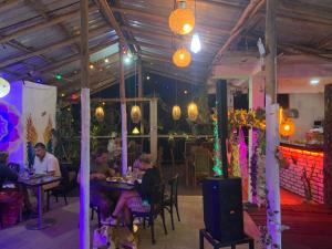 a group of people sitting at tables in a restaurant at Noname Hostel ella in Ella