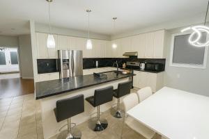 a kitchen with a counter and a table with chairs at Spacious Brampton 4BR Upper Home in Brampton